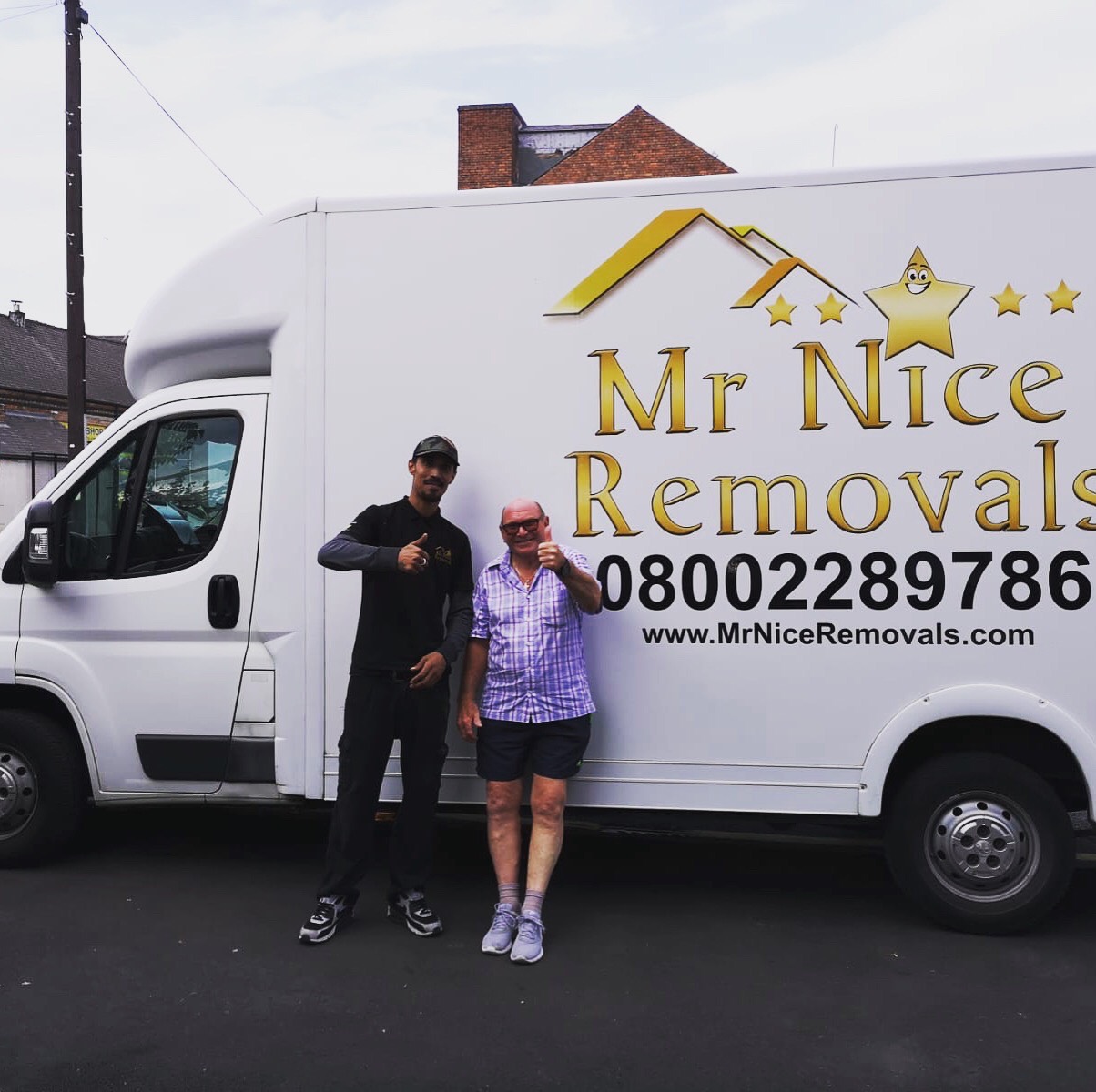 A man and woman standing in front of a removals truck.