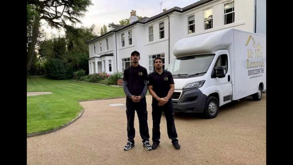 Two men standing in front of a white van.