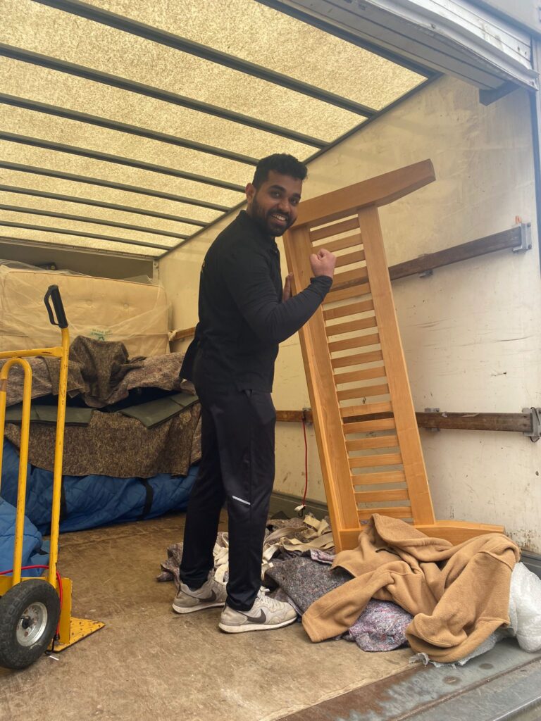 A man standing in the back of a moving truck.